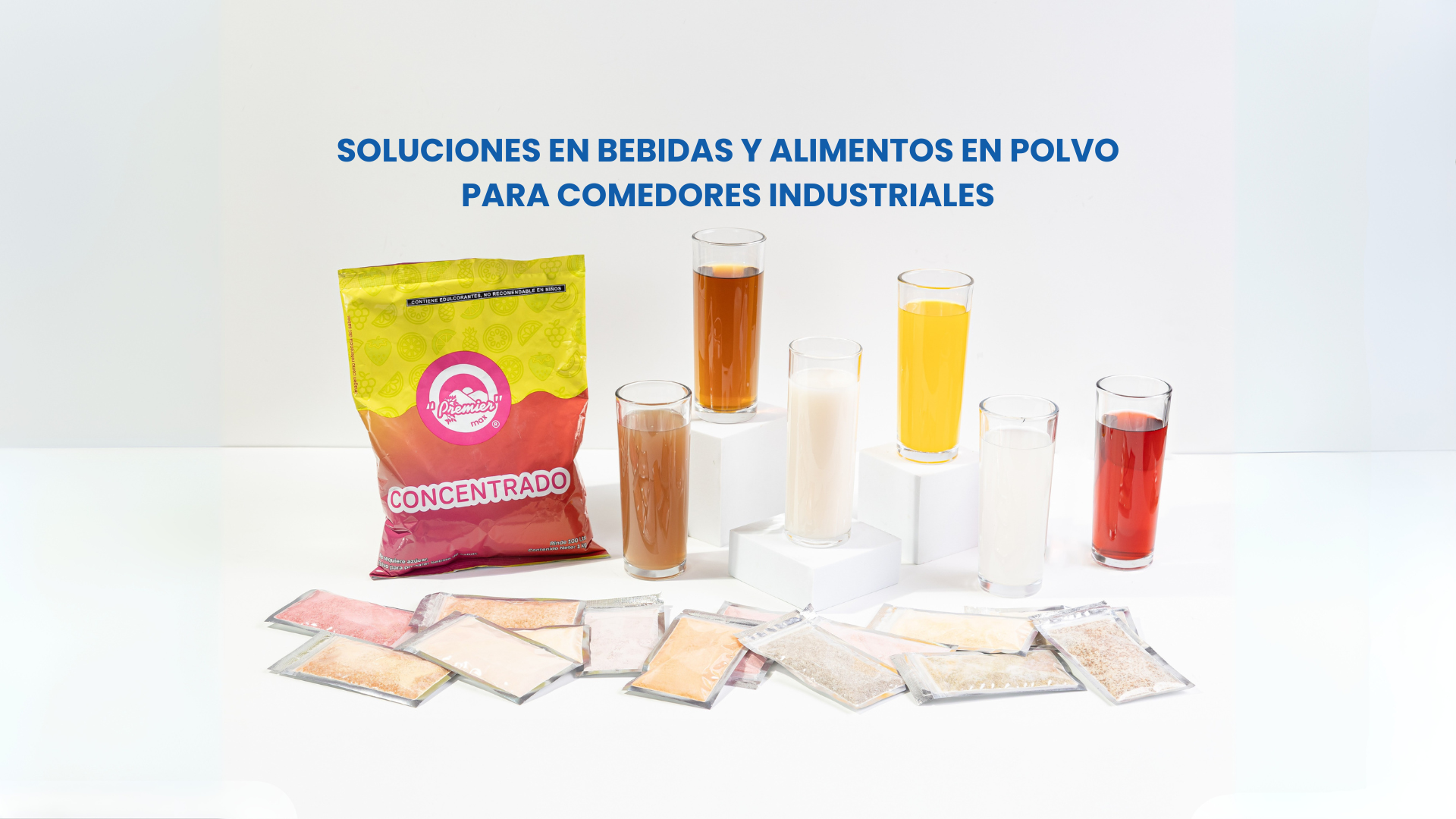 Bolsa de concentrado Premier Max junto a vasos con bebidas preparadas y sobres individuales, con el texto “Soluciones en bebidas y alimentos en polvo para comedores industriales”.
